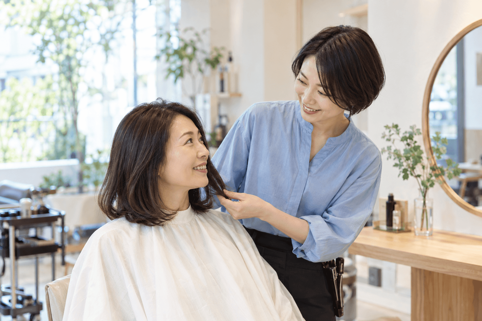 美容師とお客様が笑顔でヘアスタイルを相談する様子